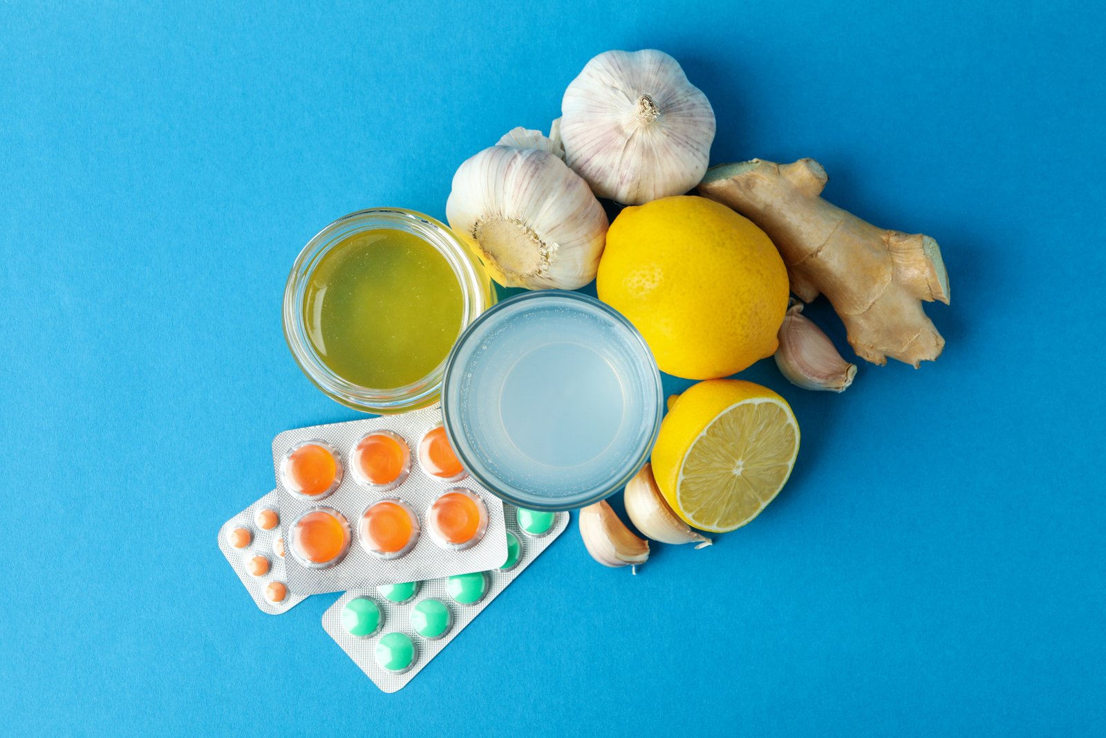 Concept of treatment colds with honey and garlic on blue background